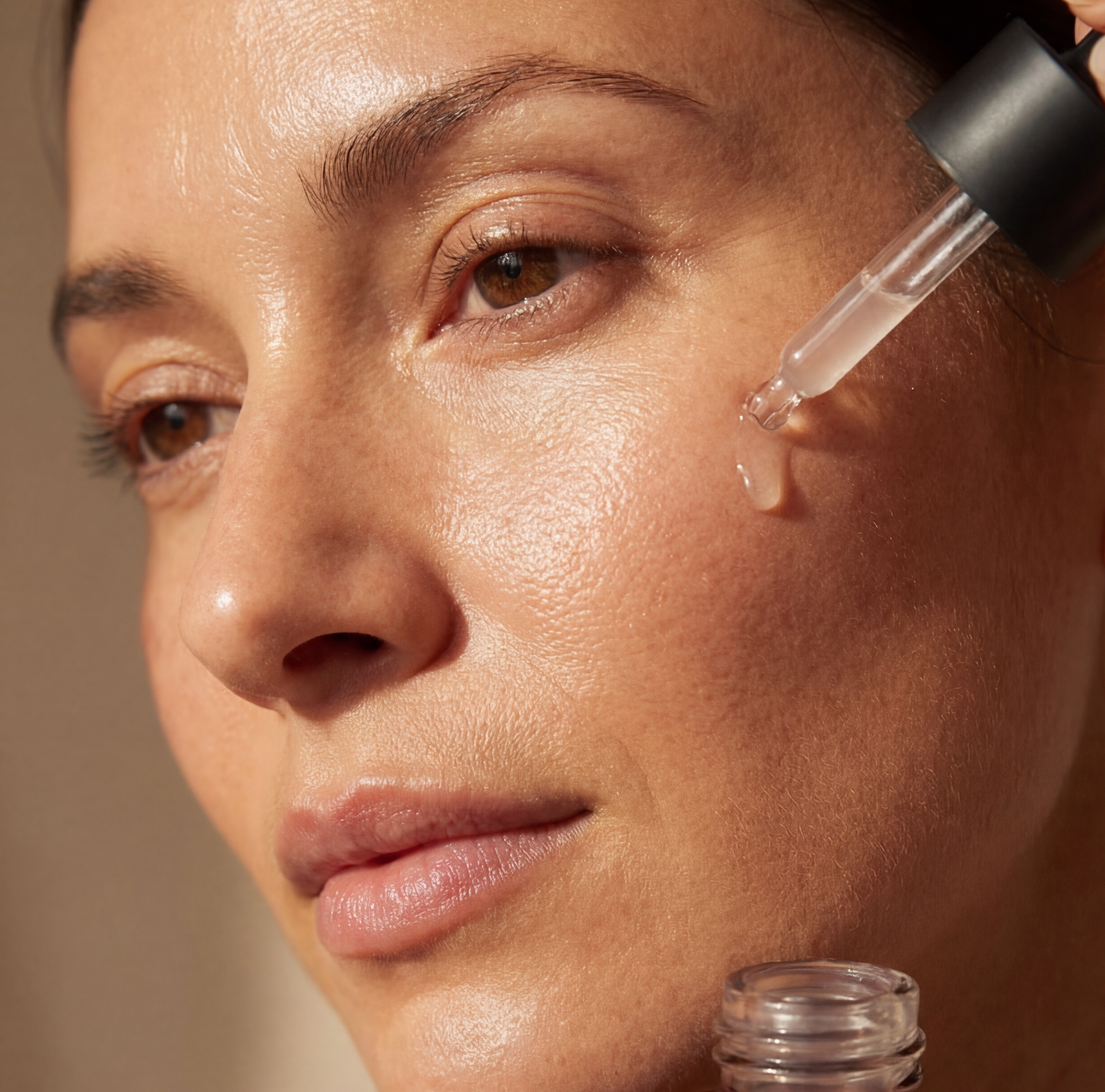 Woman applying a serum dropper to her cheek