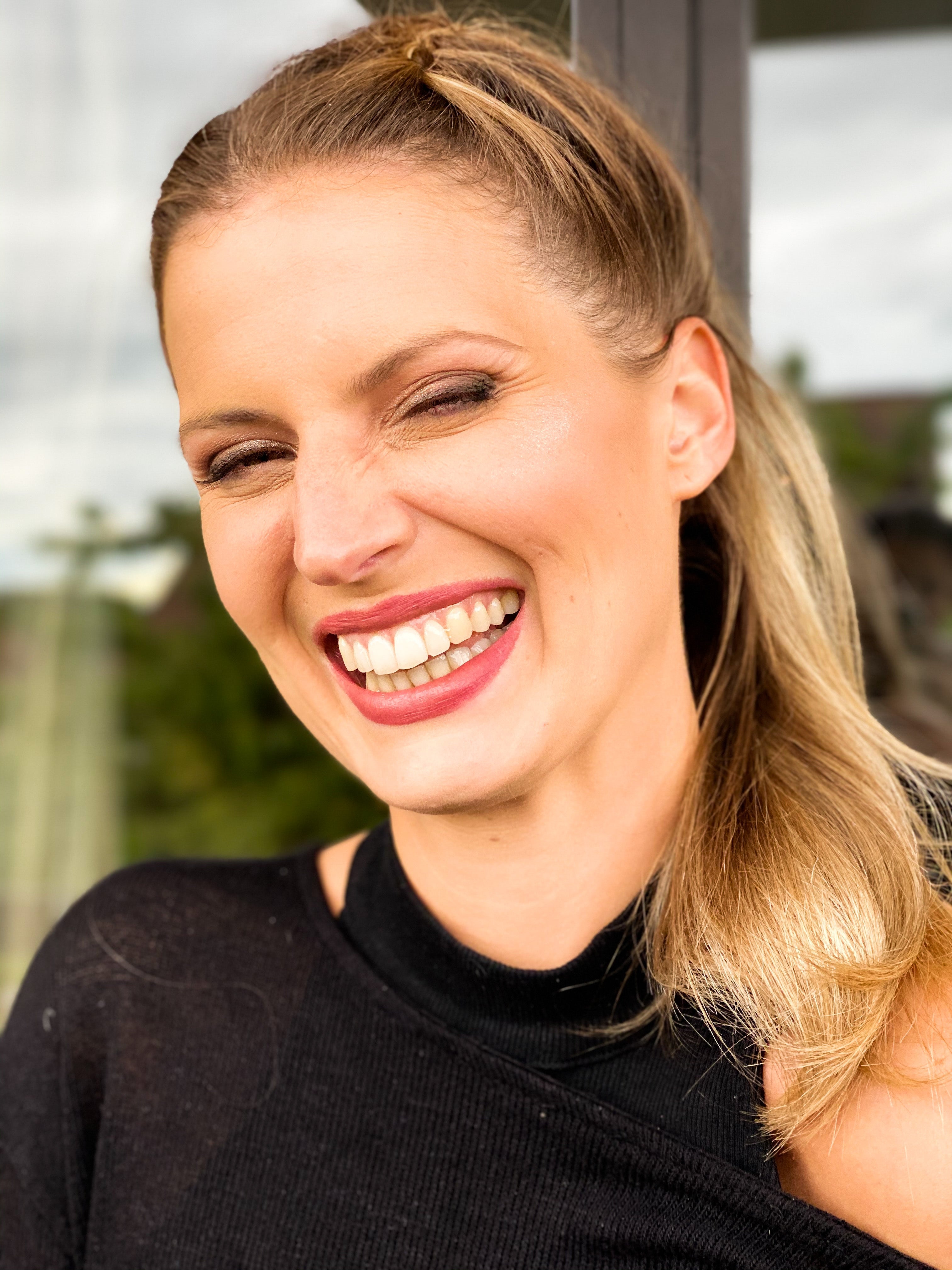 Woman smiling and winking in warm sunlight